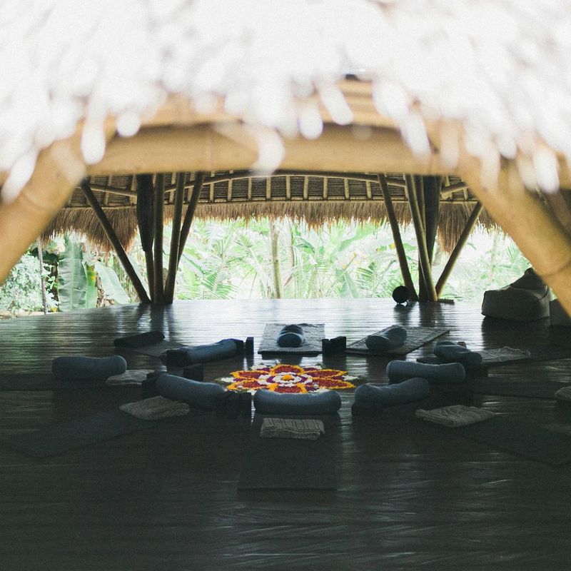 Minimalist yoga studio interior with bamboo floor and sunlight